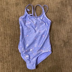 Light purple swimsuit with unicorns and stars on it